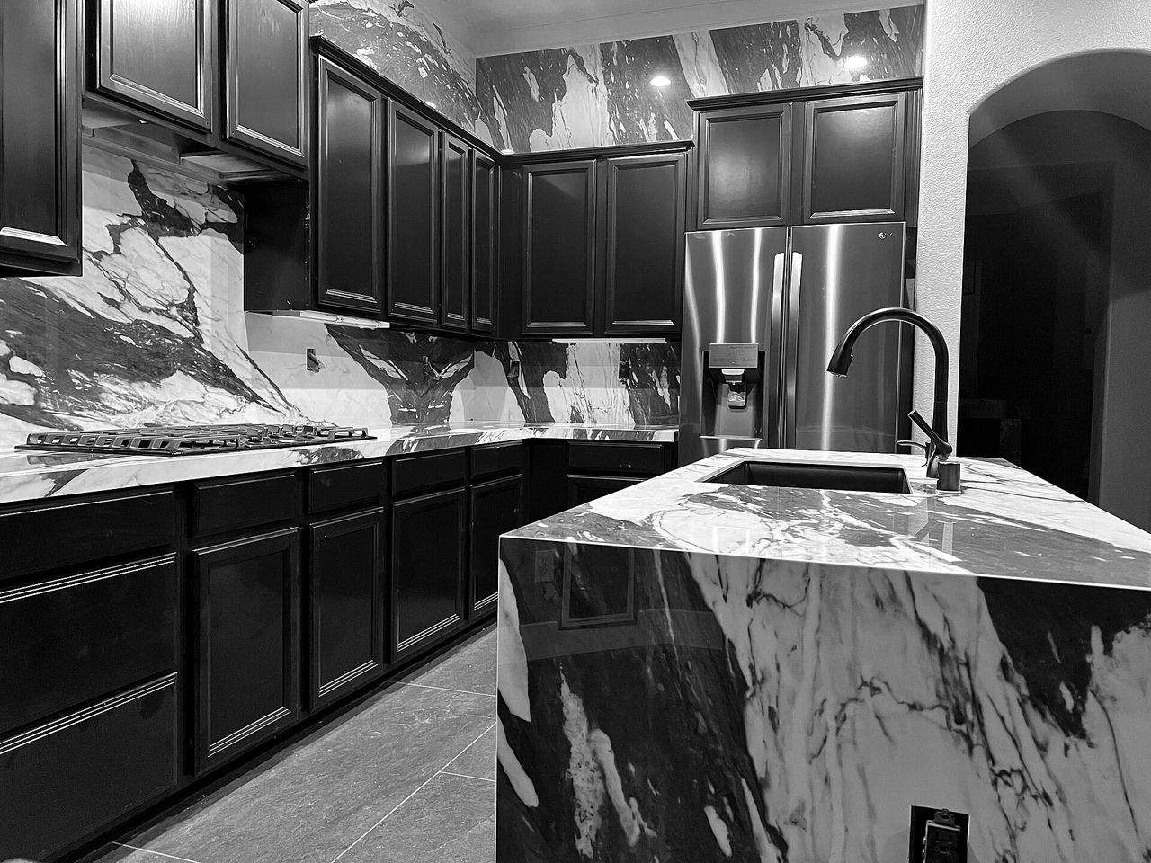 A finished kitchen with a marble waterfall island